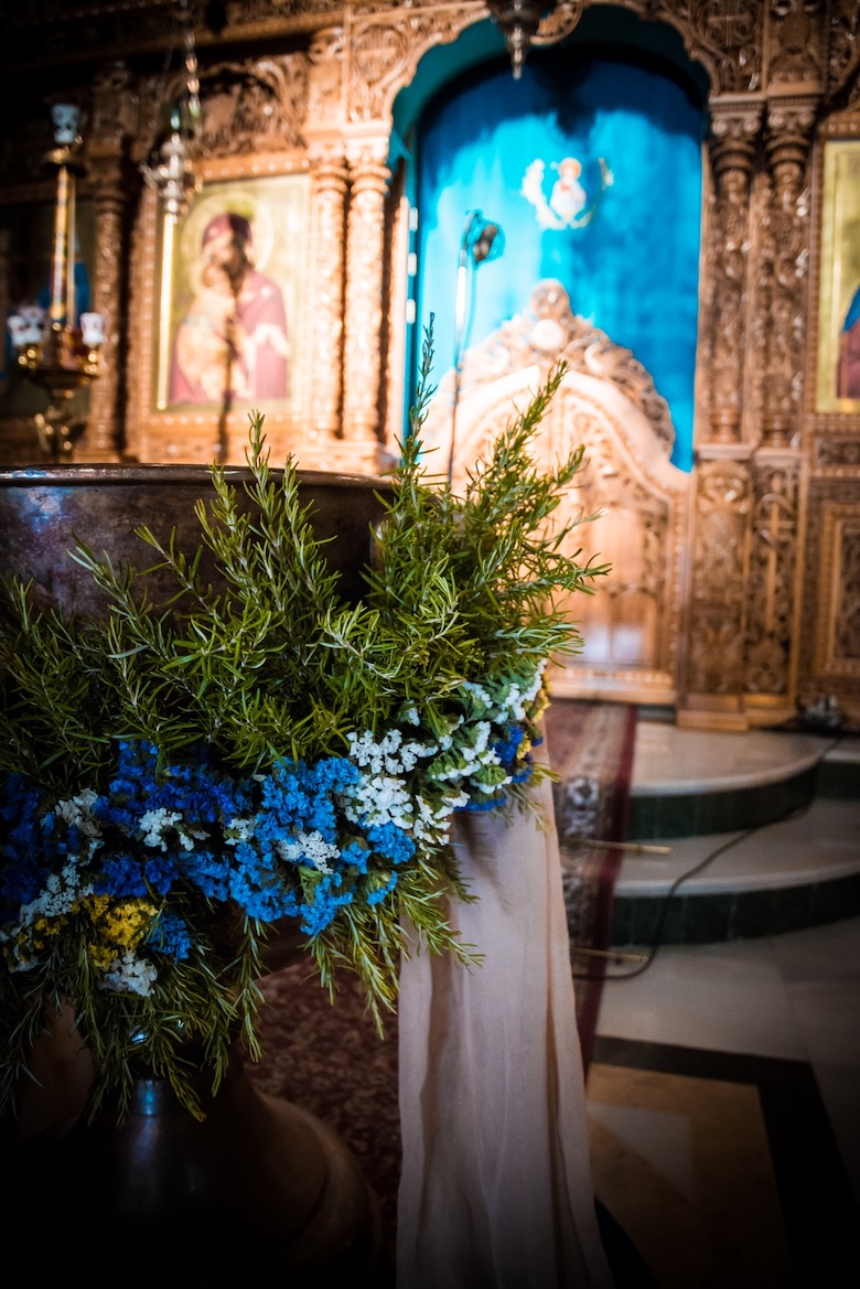 A baptism font decorated with flowers inside a church in Nafplio.