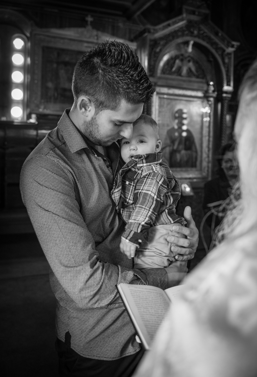 A godfather and his godchild together inside a Greek church.