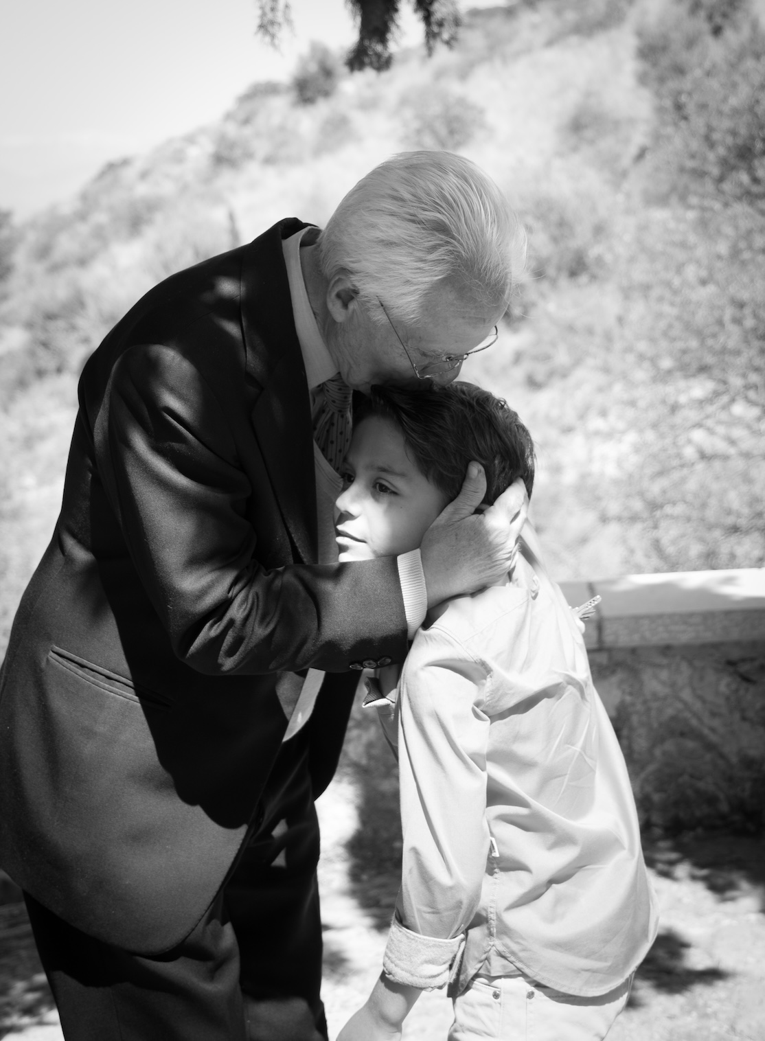 A tender moment between a grandfather and his grandson at a family celebration in Nafplio.