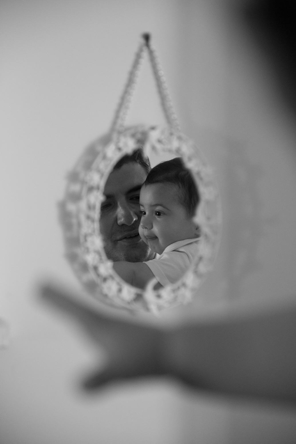 A mirror portrait reflecting a father and son at a family event in Argolis.