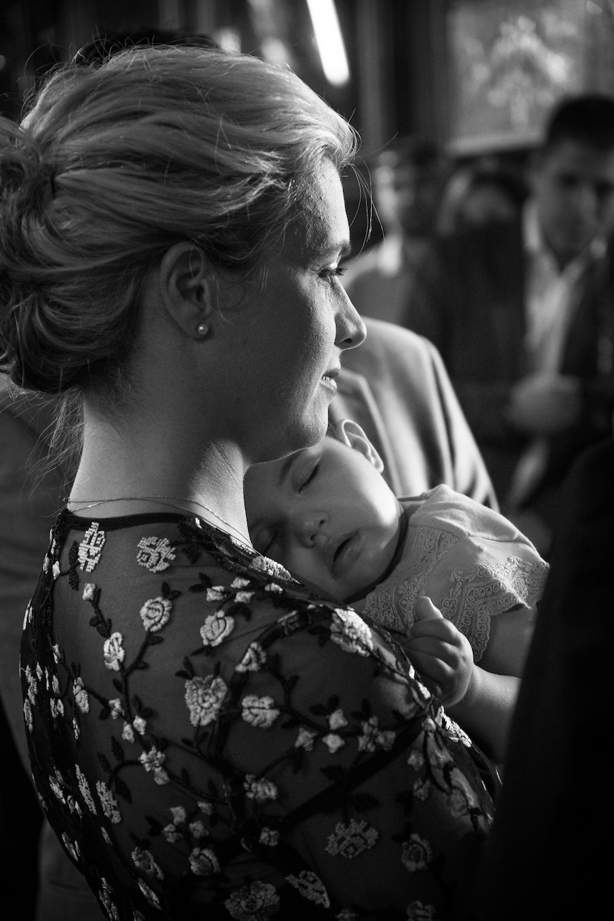 A loving moment between a mom and daughter at a Greek church celebration.