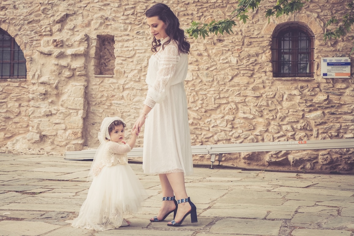 A mother and daughter wearing matching clothes at a baptism celebration in Nafplio.